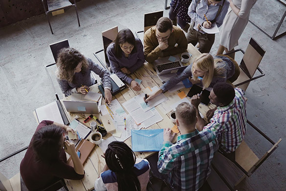 Birds eye view of a table with staff seated around as they workshop ideas